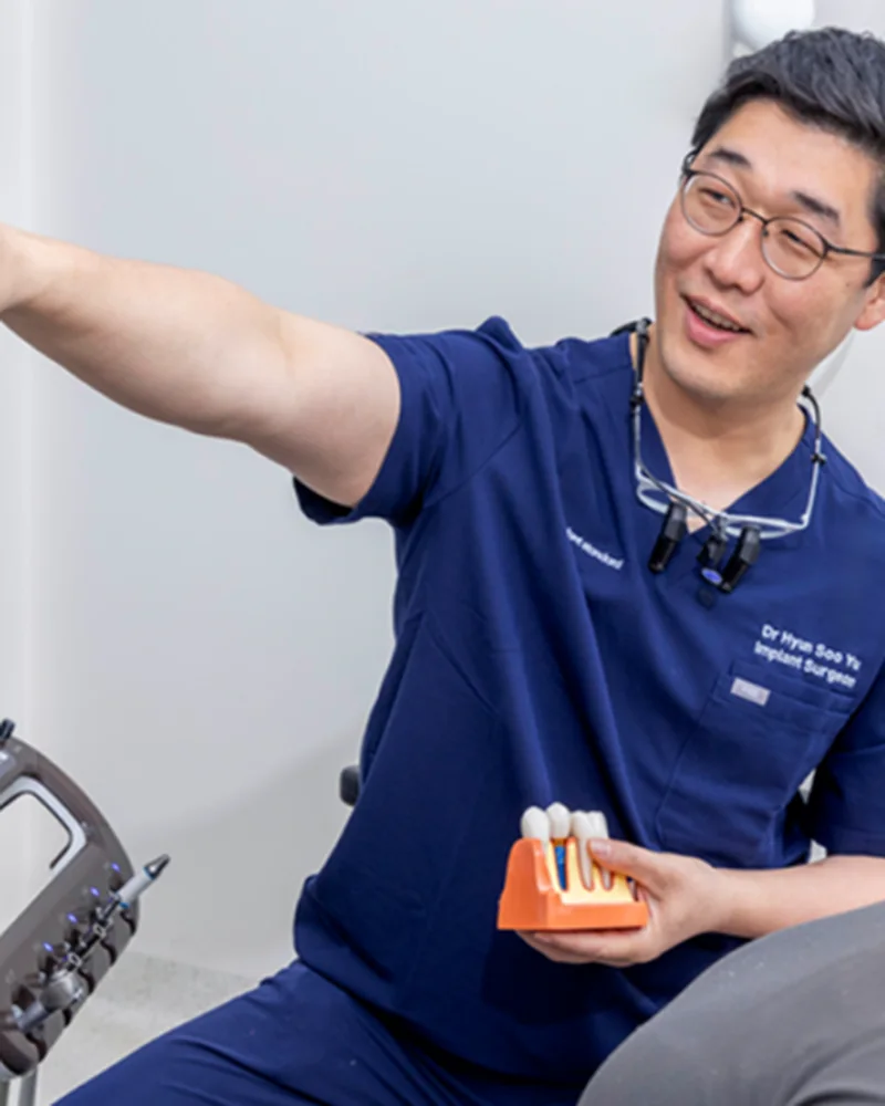 Dr Hyun Soo Yu explaining a dental implant treatment plan to a patient using 3D imaging