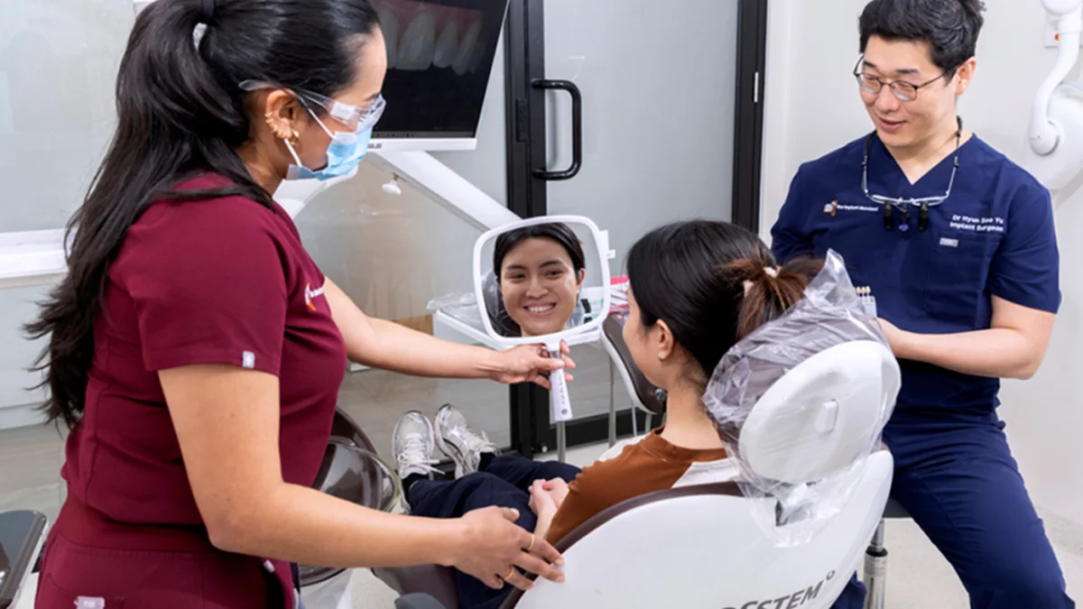 The Implant Standard team with a patient at the chair
